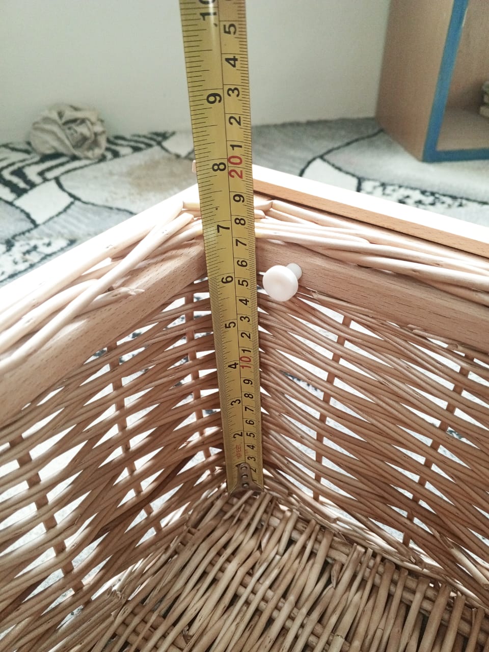 Wicker basket with a ruler for scale on a patterned surface