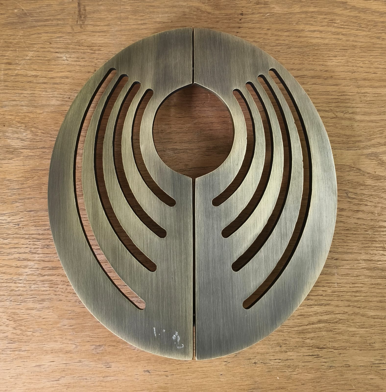 Decorative metal disc with concentric circular design on a wooden surface