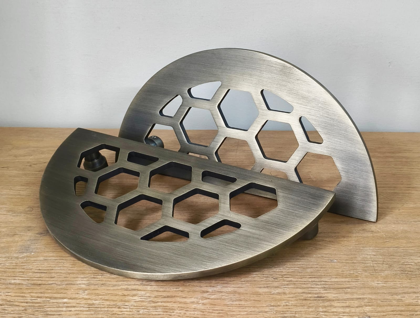 Metal trivet with honeycomb pattern on a wooden surface