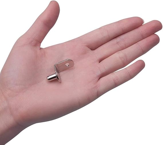 Small metal object held in the palm of a hand on a white background