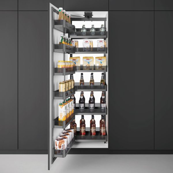 Tall, narrow pantry with shelves stocked with food items against a dark gray wall.